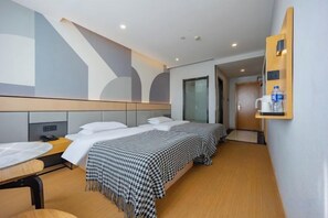 A hotel room with two beds, a desk, a chair, and a wall-mounted shelf with items. - 7 Days Inn (Ningguo Ningcheng North Road) (Xuancheng)