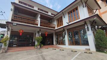 A two-story building with a balcony, large windows, and a sign indicating a new year celebration.