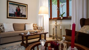 A living room with a sofa, a coffee table with decorative items, a lamp, and a painting on the wall.