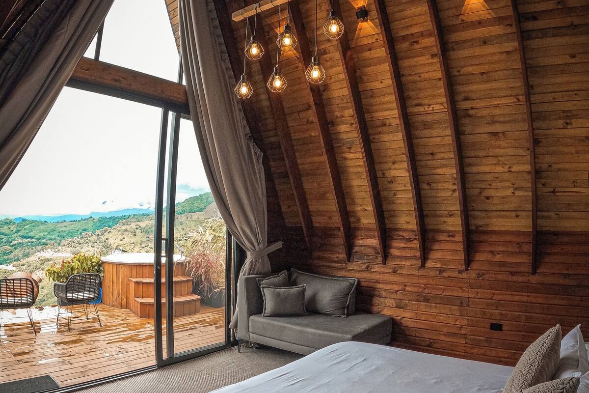 Une chambre avec un grand lit, un canapé et une vue sur un paysage montagneux.