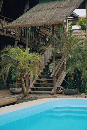 A wooden staircase leading to a covered area with a pool in the foreground. - La Fauna Hotel (Tambopata)