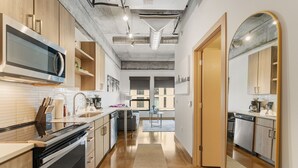 Een moderne keuken met roestvrijstalen apparatuur, houten kastjes en een centraal eiland.