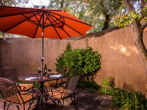 Relax in the shaded patio area with a round table and four comfortable chairs.
