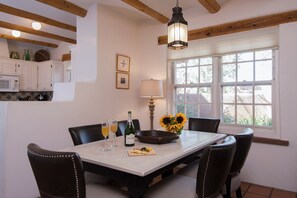 Enjoy a romantic dinner for two in this cozy dining area, complete with a table set for two, wine, and snacks.
