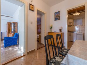 Un appartement moderne comprenant un coin repas, une cuisine et un salon avec un canapé bleu.