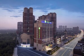 Een Holiday Inn Express hotel met een modern design, gelegen in een stedelijk gebied met omliggende hoogbouw.