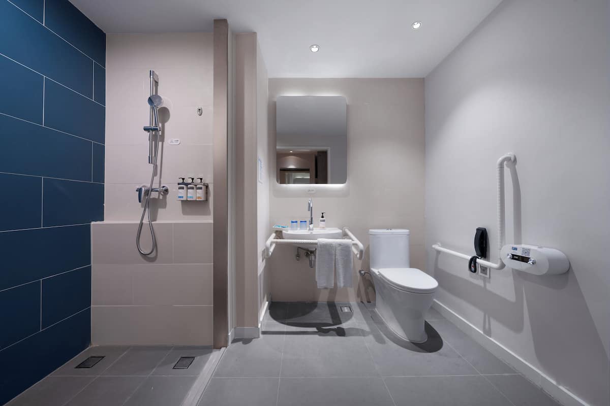 A modern bathroom with a walk-in shower, a toilet, and a sink.