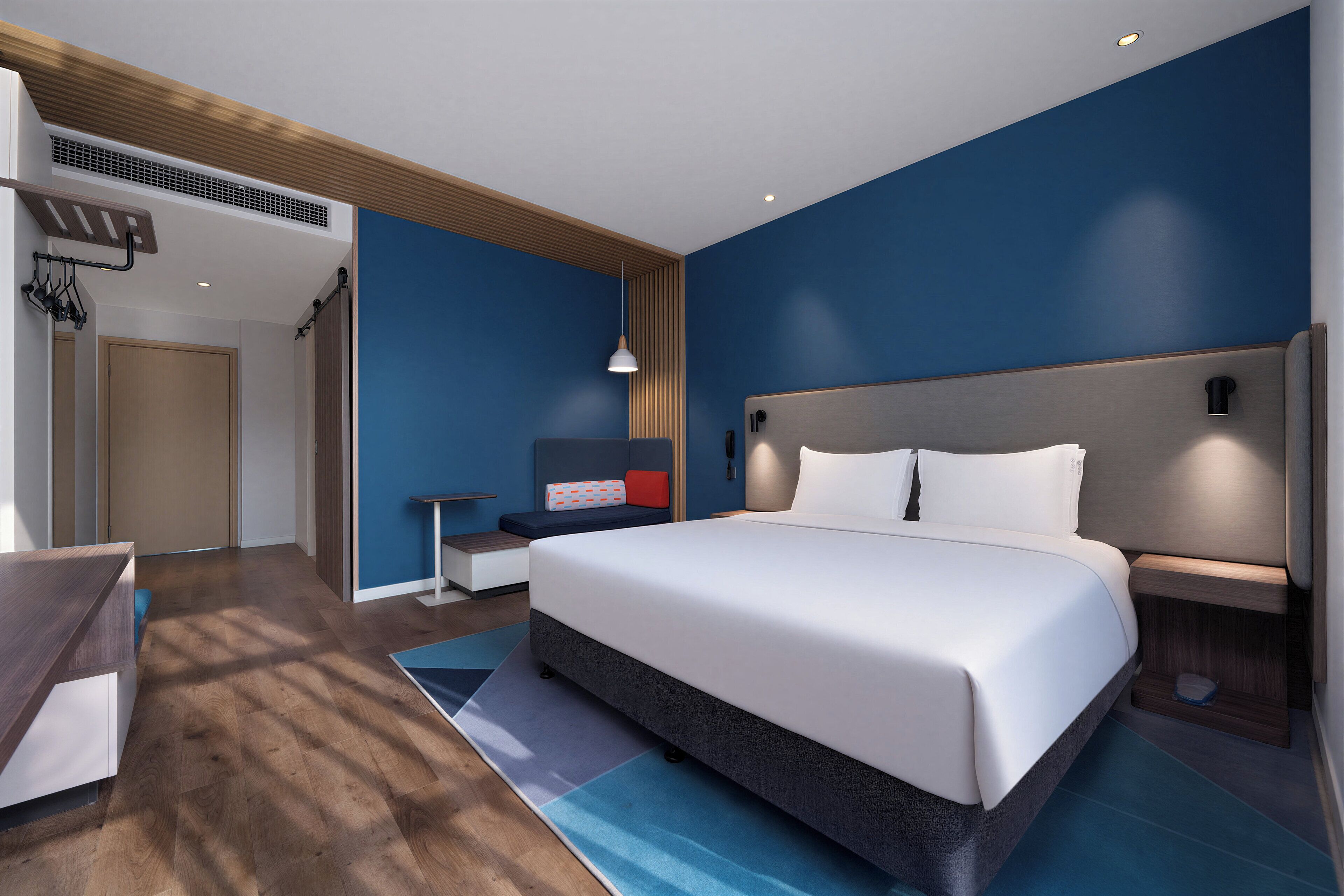 Een moderne hotelkamer met een groot bed, een bureau en een zithoek.