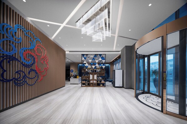 A modern hotel lobby with a wooden reception desk, a geometric wall design, and a large chandelier. - Holiday Inn Express Pengzhou Downtown by IHG (Chengdu)