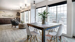 A dining area with a wooden table, white chairs, and a potted plant. - SCP Depoe Bay (Depoe Bay)