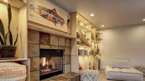A cozy living room with a fireplace, a bookshelf, and comfortable seating. - SCP Depoe Bay (Depoe Bay)