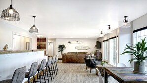A modern kitchen with a bar area, wooden flooring, and pendant lighting. - SCP Depoe Bay (Depoe Bay)