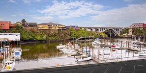 A marina with boats docked, a bridge in the background, and buildings along the riverbank. - SCP Depoe Bay (Depoe Bay)
