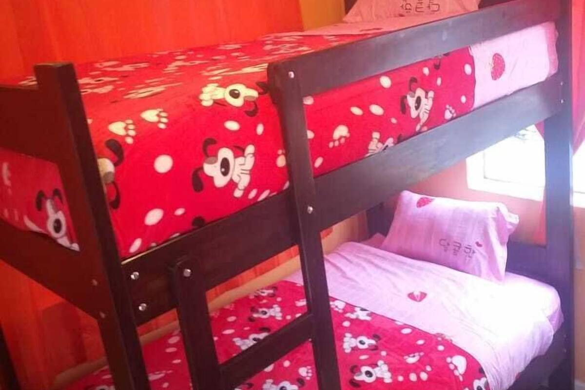 Ein Stockbett mit einer roten und weißen Bettdecke mit Minnie Maus Design.