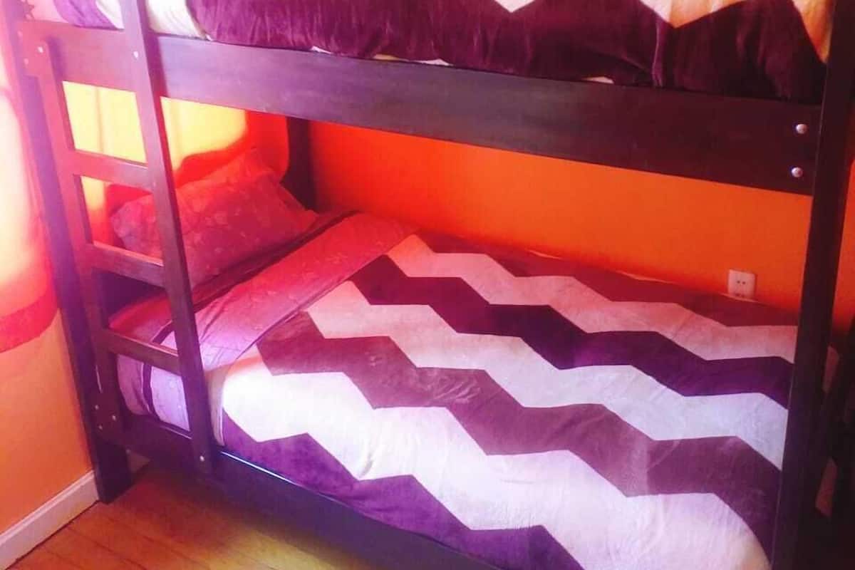 Ein Etagenbett mit einem chevron-mustertooMatratze in einem Raum mit orangefarbenen Wänden.