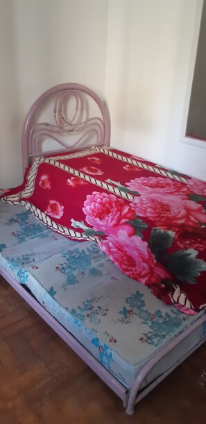 Una cama con una colcha estampada con motivos florales y un cabecero.