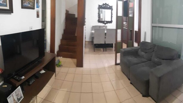 Un salon équipé d’un téléviseur à écran plat, d’un canapé, d’un escalier et d’un coin repas.