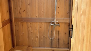 Eine Holzterrasse mit integriertem Duschbereich.