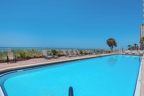 A clear blue pool with lounge chairs and a view of the ocean. - Twin Palms 1002 by Best Beach Getaways (Panama City Beach)
