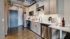 Una cocina moderna con electrodomésticos de acero inoxidable, un microondas y una cafetera.