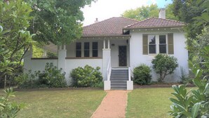 A two-story house with a tiled roof, a front porch, and a small front yard with a pathway leading to the entrance. - Casa Antica, 200m walk to Bowral Township, family friendly and strictly NO PETS! (Bowral)