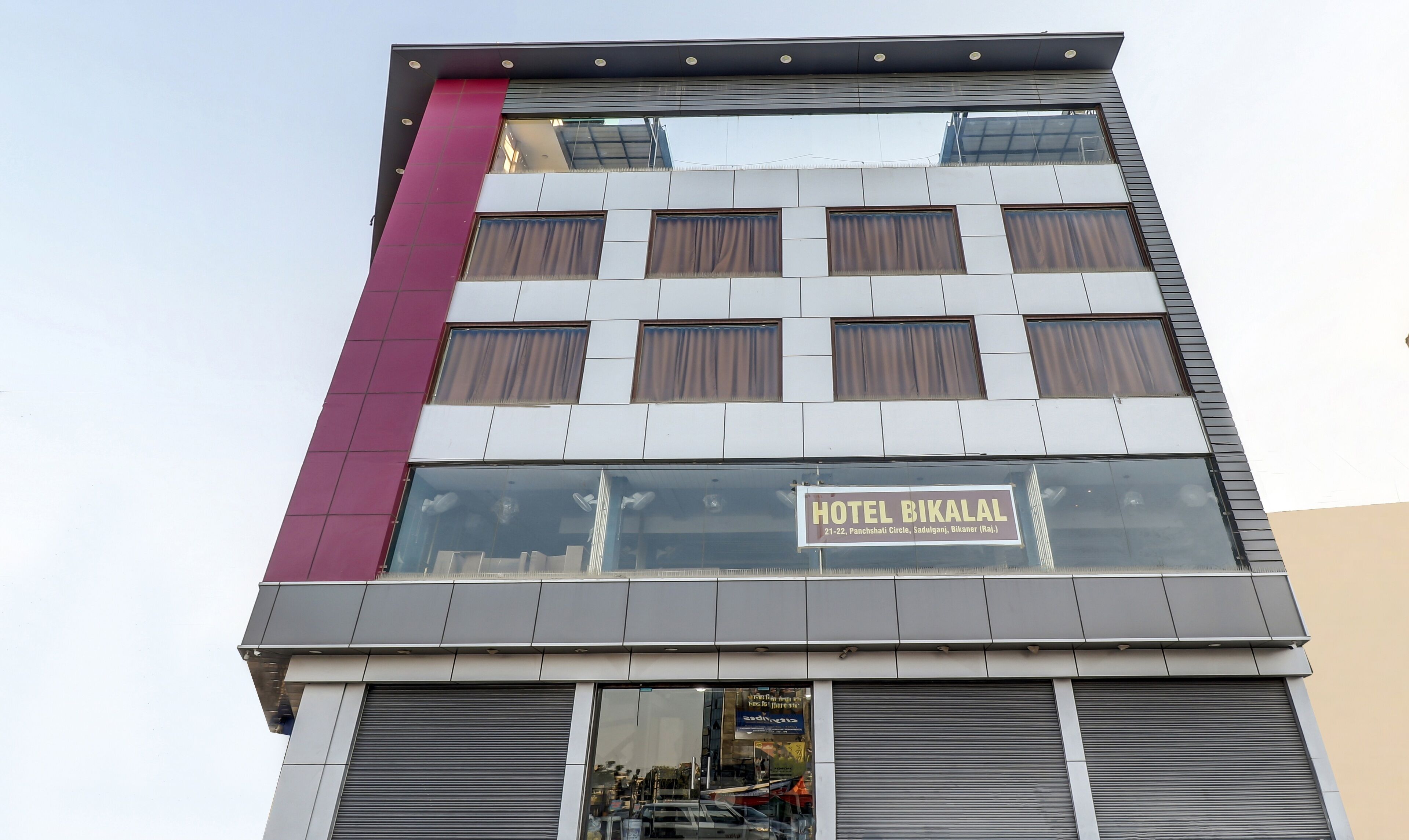 A hotel with a sign reading "HOTEL BIKALAL" and a modern architectural design.