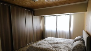 A bedroom with a bed, a wardrobe, and a window with curtains. - City of the Sun Newly renovated loving house (Nairobi)