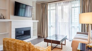 A modern living room with a fireplace, a flat-screen TV, a sofa, and a coffee table.