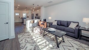 A modern living room with a gray sofa, a coffee table, and a patterned rug. - *2bd/2.5bth | Near Downtown| Soccer Stadium* #D (Nashville)