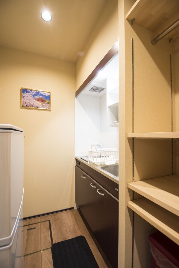 Una cocina compacta con refrigerador, lavavajillas y una pequeña encimera.