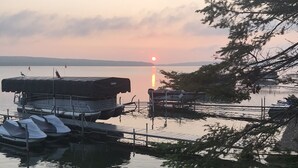 Un lago calmo al tramonto con barche ormeggiate a un pontile.