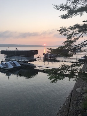 Enjoy serene lakeside views from the dock, where boats are moored and a bridge connects to the opposite shore.