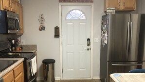 A kitchen with wooden cabinets, a stainless steel refrigerator, a microwave, and a stove.