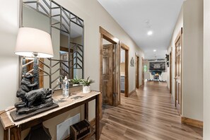 Enter a warm and inviting space with a cozy living area featuring a fireplace and a large mirror.