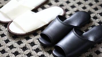 Une paire de pantoufles noires et blanches sur un tapis à motifs.