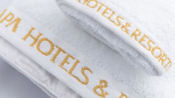 A white towel with "IPA Hotels & Resort" embroidered in gold.