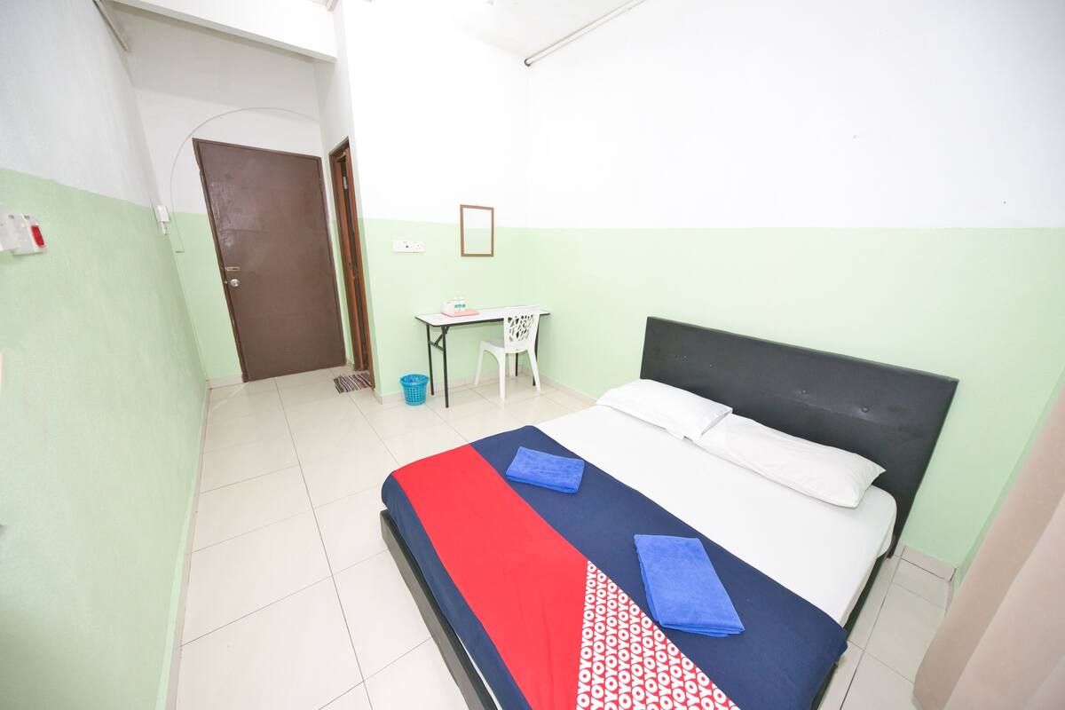 A room with a bed, a desk, and a chair.