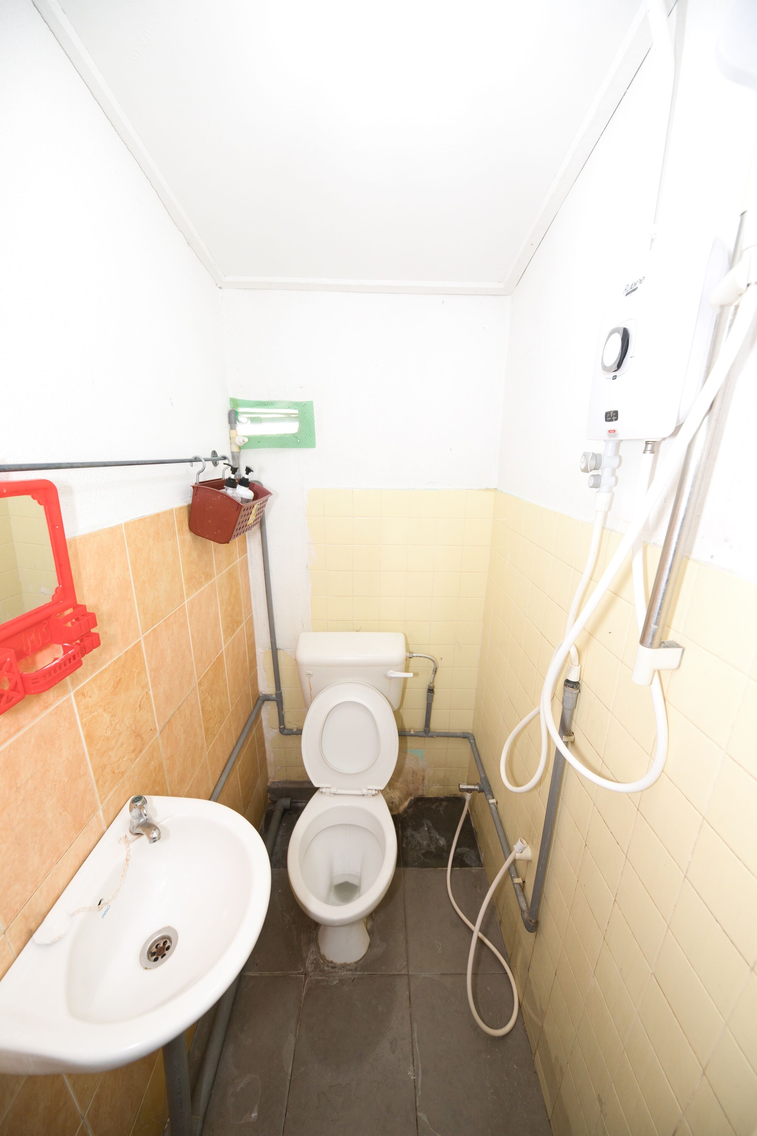 A small bathroom with a toilet, sink, and shower.