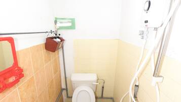 A small bathroom with a toilet, sink, and shower.