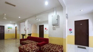 A hotel room with two red sofas, a small table, and a door marked 102. - Hotel O Innap Kota Bharu (Kota Bharu)