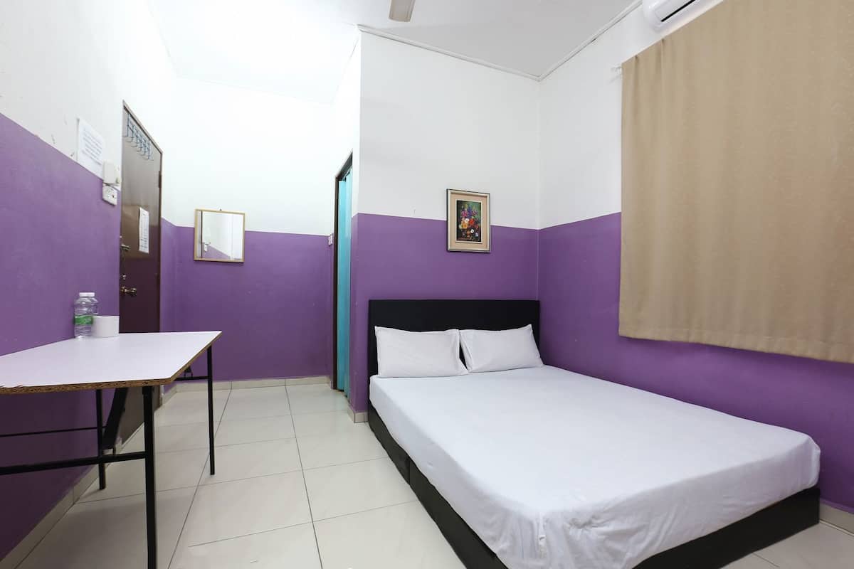 A room with a bed, a desk, a window with a curtain, and a door.