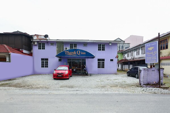 Un edificio con fachada morada y un letrero que dice "Thank Q inn".