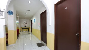 A hallway with a clock, a door labeled '101', and a bench. - Hotel O Innap Kota Bharu (Kota Bharu)