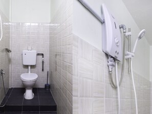 A bathroom with a toilet, a shower, and a wall-mounted toilet paper holder. - Hotel O City Hostel Ipoh (Ipoh)