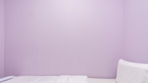 A single bed with white bedding in a room with light purple walls. - Hotel O City Hostel Ipoh (Ipoh)