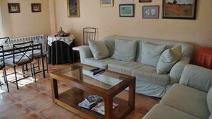 Un salon comprenant un canapé, une table basse et une table à manger avec des chaises.