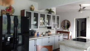 A modern kitchen with a black refrigerator, white cabinets, and a built-in oven.