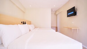 A hotel room with a large bed, a TV mounted on the wall, and a wooden headboard. - Bridge Hotel Express (Cagayan de Oro)