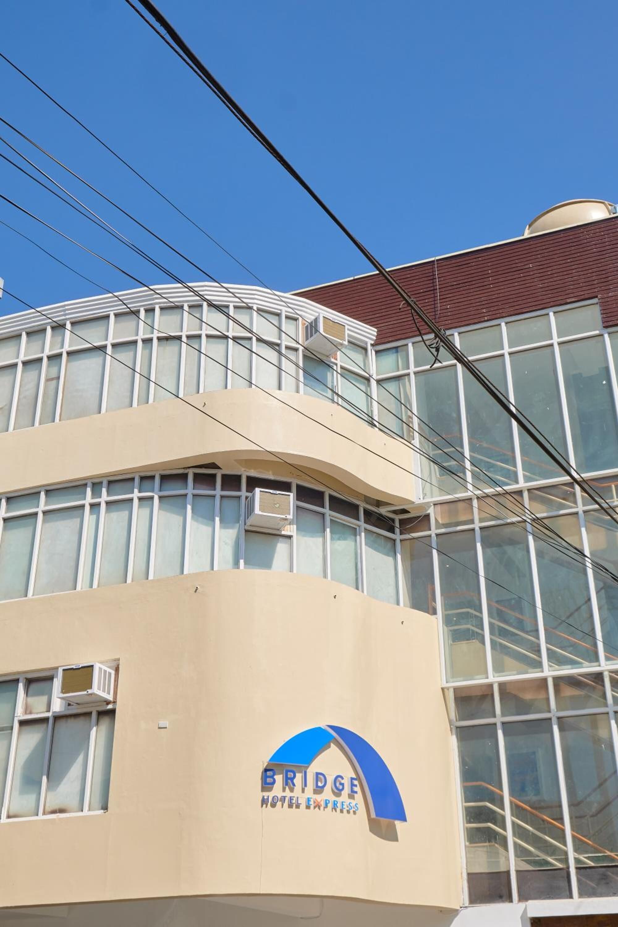 A hotel with a curved facade, large windows, and a prominent logo.
