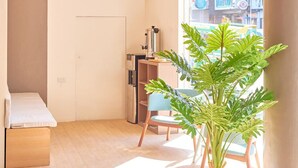 A modern room with a sloped ceiling, a potted plant, a bench, and a view of the outside. - Bridge Hotel Express (Cagayan de Oro)